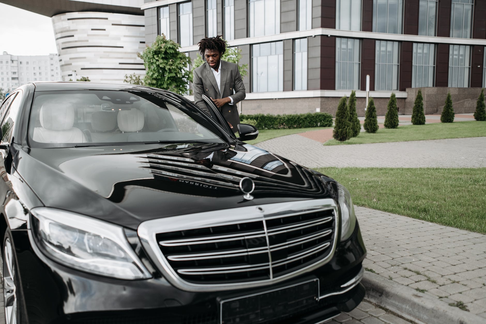 photo of a man getting in a black car