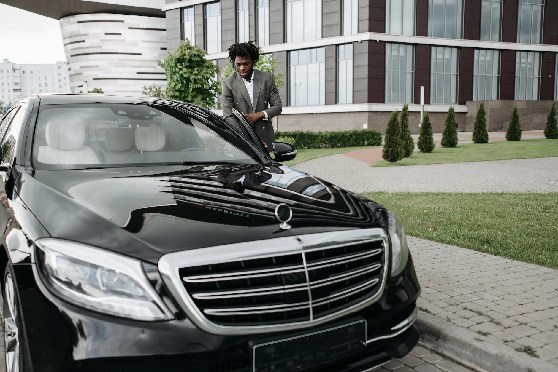 photo of a man getting in a black car